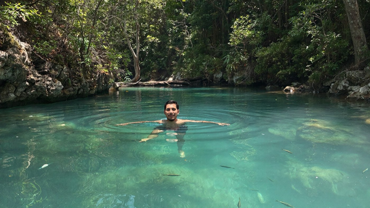 Kain Arrieta flotando en un cenote de agua turquesa en la selva de la Riviera Maya