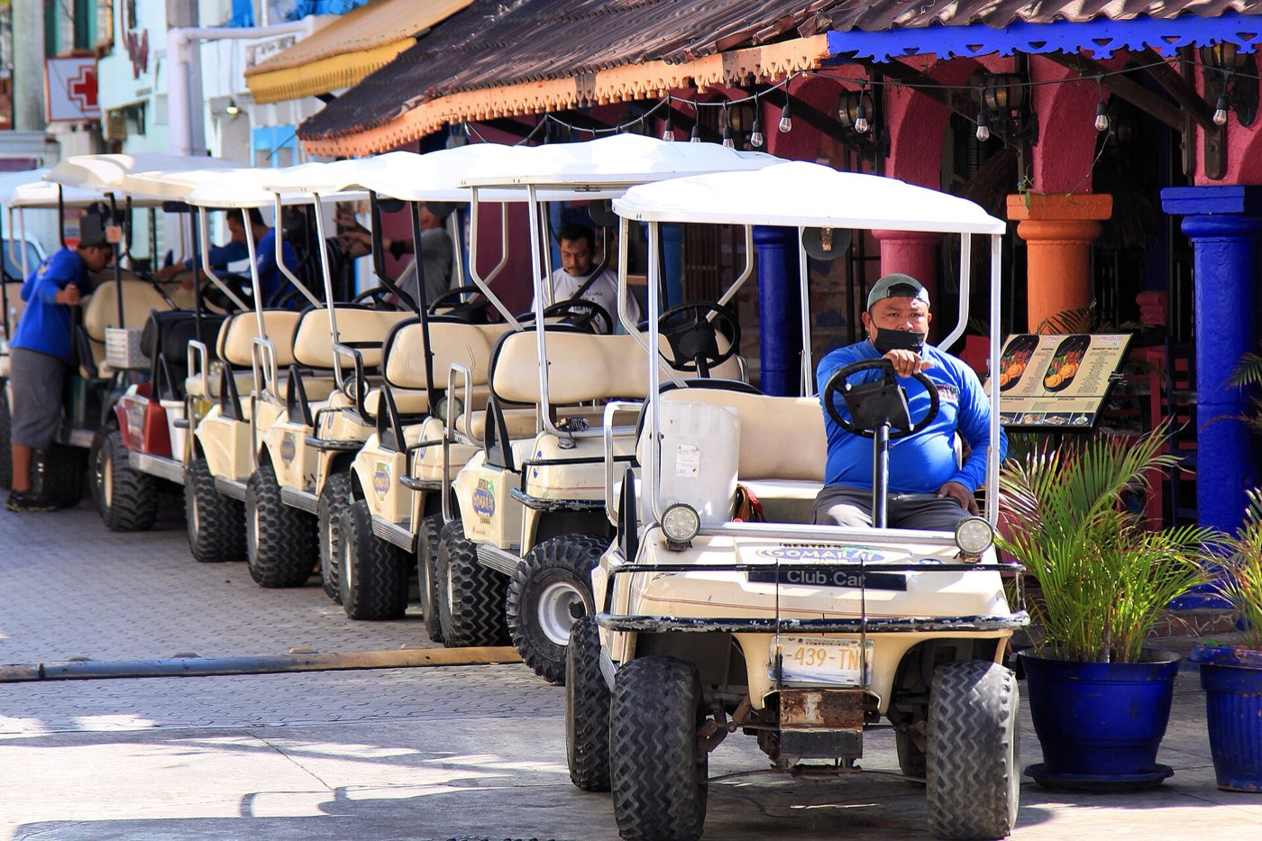 Fila de carritos de golf para rentar en el centro de la isla