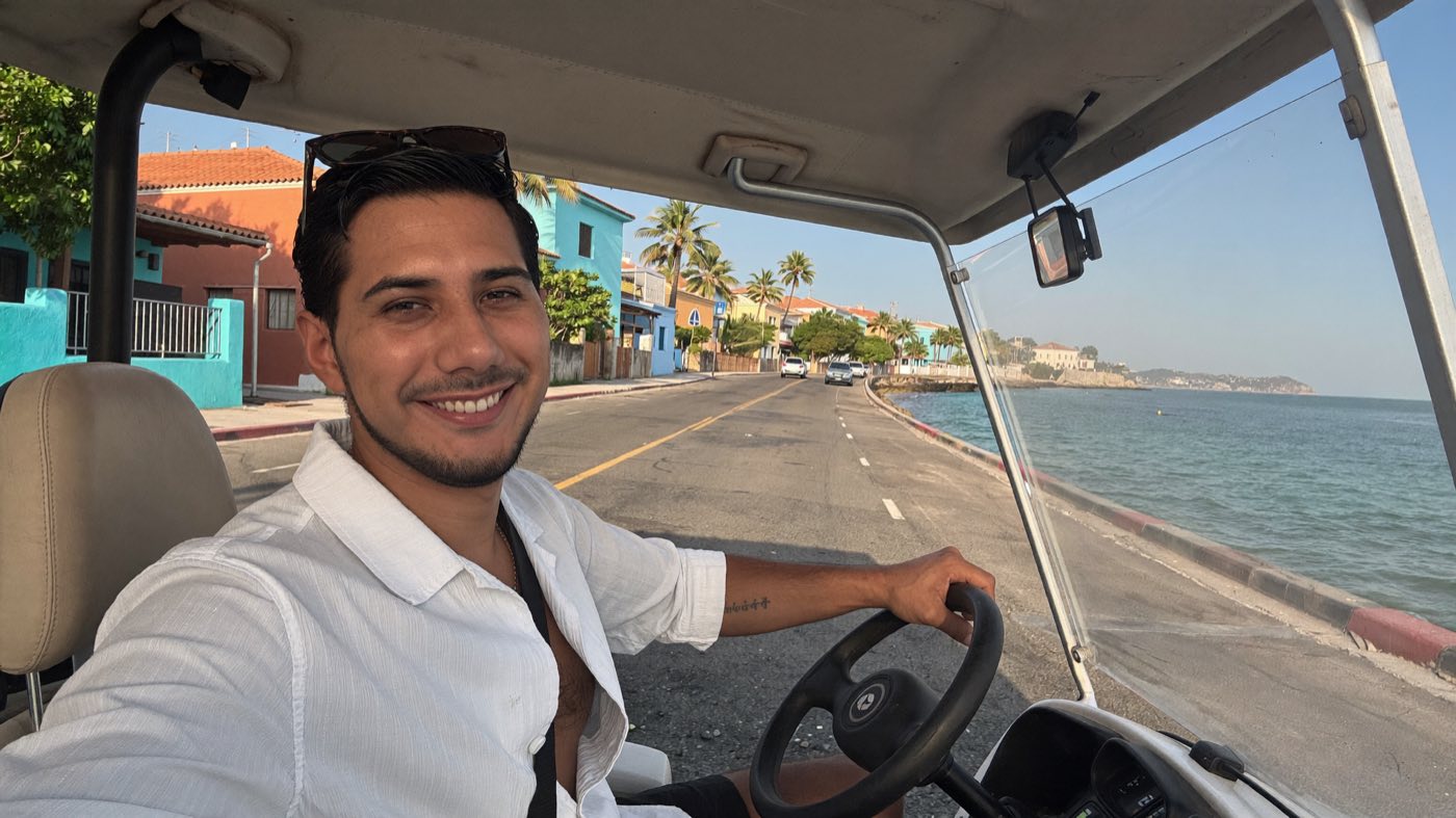 Kain Arrieta manejando un carrito de golf por la costa de Isla Mujeres